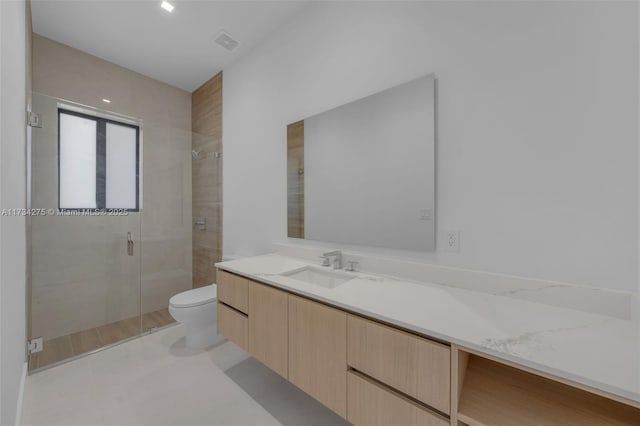 bathroom featuring vanity, toilet, and an enclosed shower