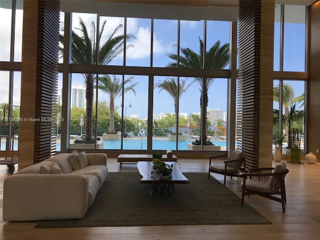 living room with hardwood / wood-style flooring, expansive windows, and a water view