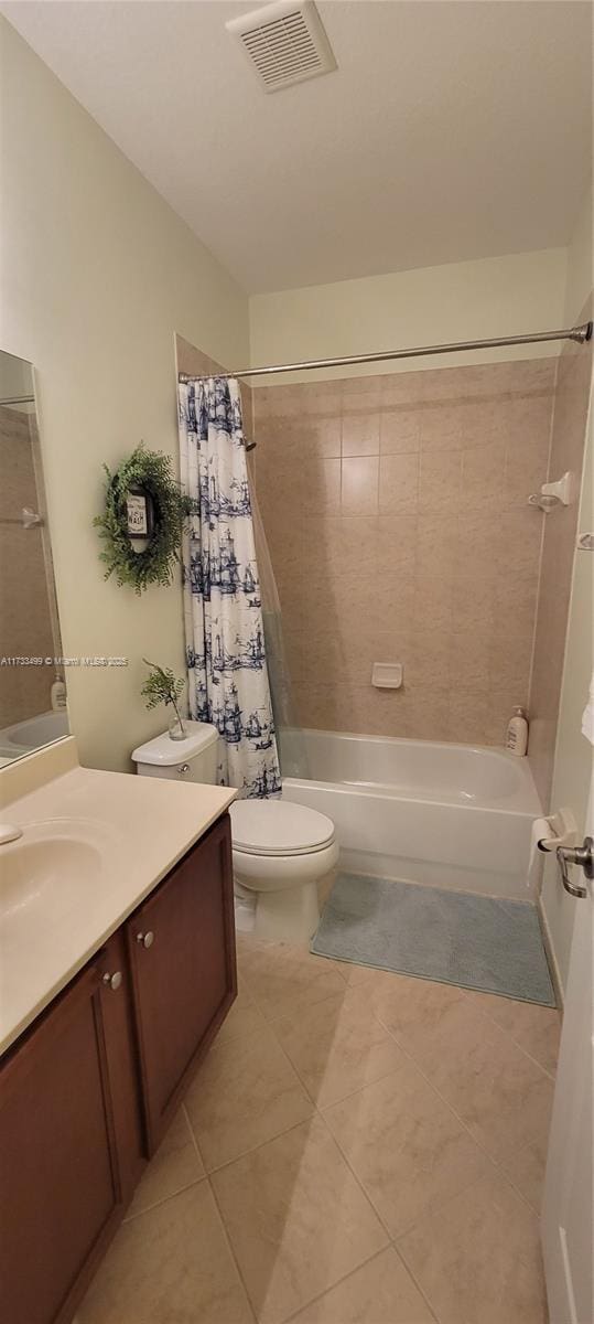 full bathroom with shower / bath combination with curtain, vanity, tile patterned floors, and toilet