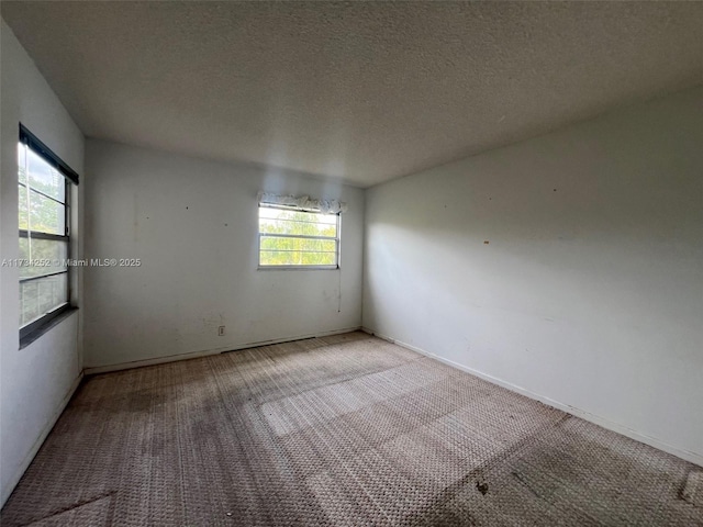 carpeted spare room featuring a textured ceiling