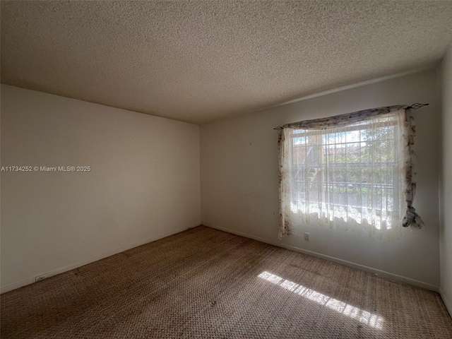 carpeted spare room featuring a textured ceiling