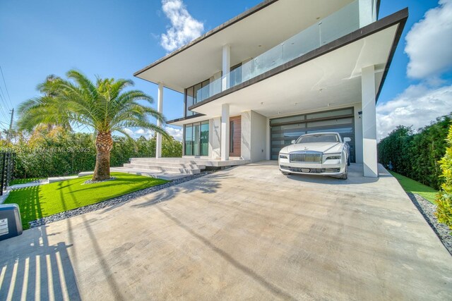 contemporary house featuring a garage and a balcony