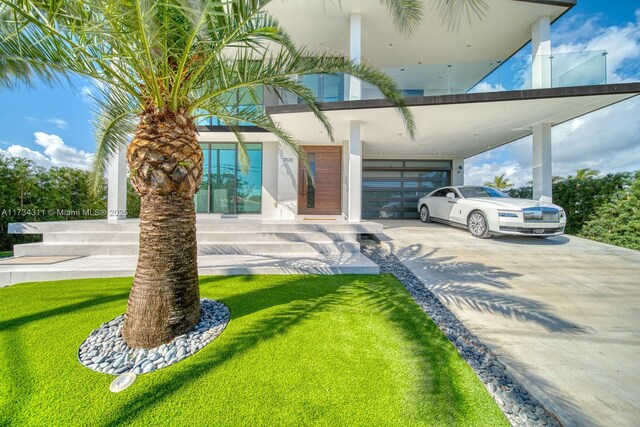 exterior space featuring a front yard, a carport, and a balcony