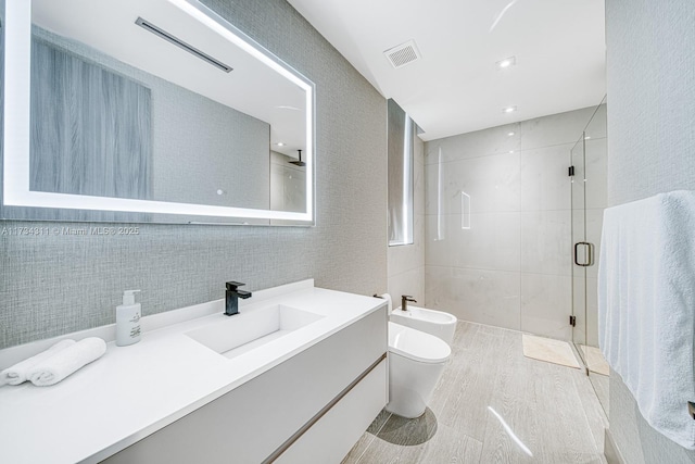 bathroom with walk in shower, toilet, tile walls, a bidet, and vanity