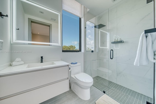 bathroom with vanity, toilet, and a shower with shower door