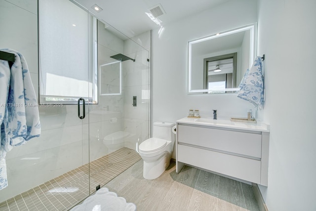 bathroom with vanity, an enclosed shower, and toilet