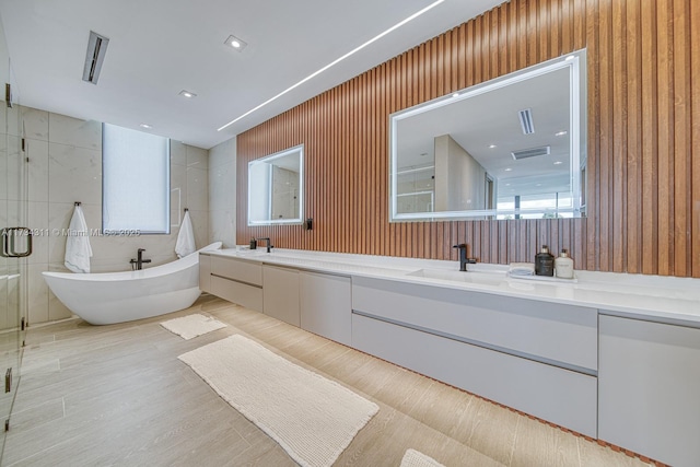 bathroom featuring vanity and independent shower and bath