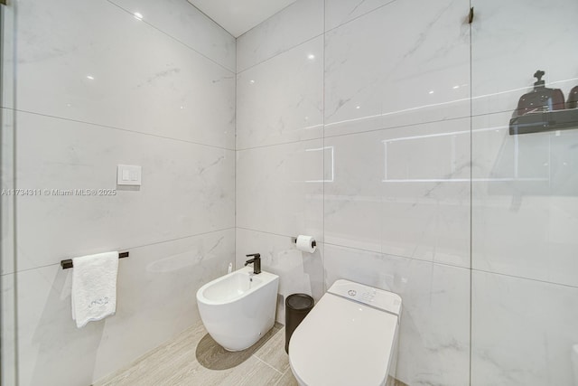 bathroom featuring a bidet, tile walls, and toilet