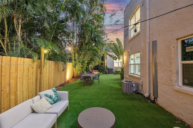 yard at dusk featuring an outdoor hangout area and central AC unit