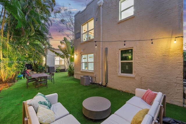 yard at dusk with an outdoor hangout area and central AC unit