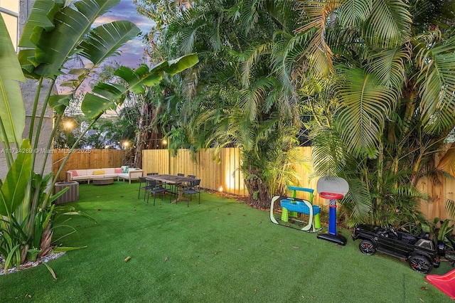 yard at dusk with an outdoor living space and cooling unit