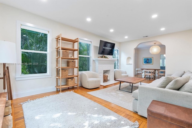 living room featuring light hardwood / wood-style floors and a brick fireplace