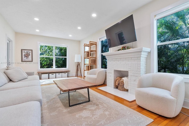 living room featuring hardwood / wood-style floors and a brick fireplace