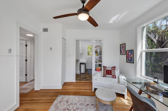 living area featuring hardwood / wood-style flooring and ceiling fan