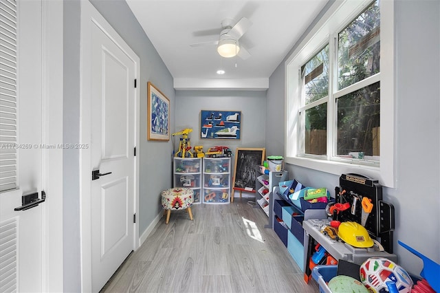 recreation room with ceiling fan and light hardwood / wood-style floors