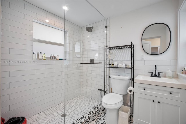 bathroom featuring vanity, toilet, and tiled shower