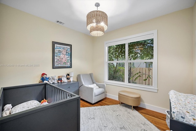 bedroom featuring hardwood / wood-style floors and a chandelier