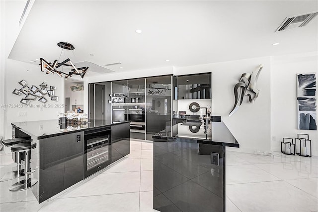 kitchen with a kitchen breakfast bar, light tile patterned floors, a spacious island, and hanging light fixtures