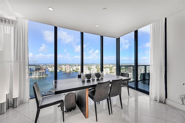 dining space with expansive windows and a water view