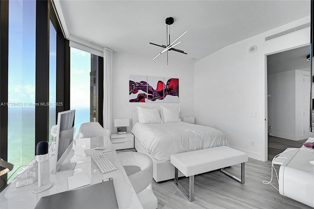 bedroom featuring light hardwood / wood-style flooring and expansive windows