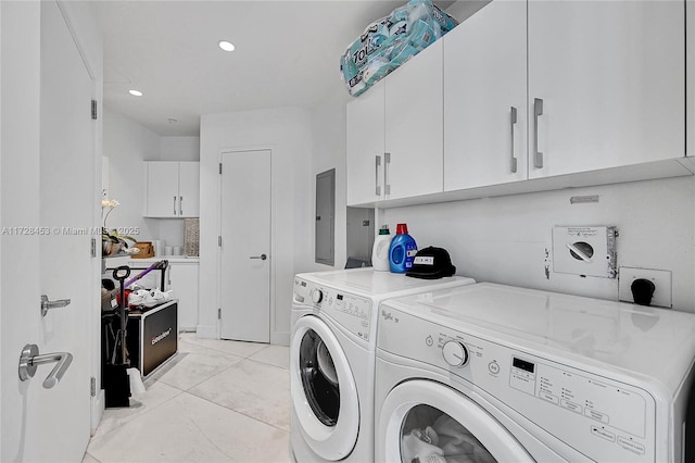 laundry room with cabinets, electric panel, and washing machine and clothes dryer