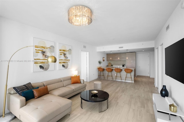 living room with a chandelier and light hardwood / wood-style floors