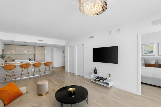 living room with a chandelier and light hardwood / wood-style floors