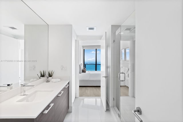 bathroom with tile patterned flooring, vanity, and a shower with door