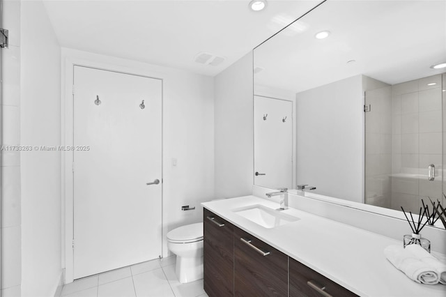 bathroom with vanity, a shower with door, tile patterned floors, and toilet