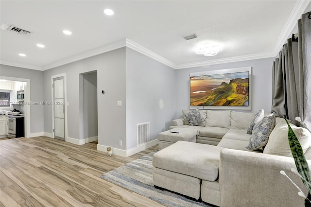 living room with ornamental molding and light hardwood / wood-style flooring