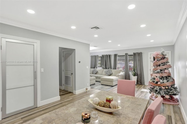 dining room with ornamental molding and light wood-type flooring