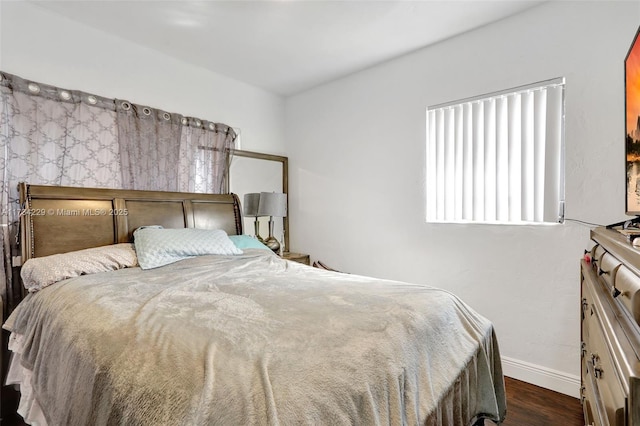 bedroom with dark hardwood / wood-style flooring