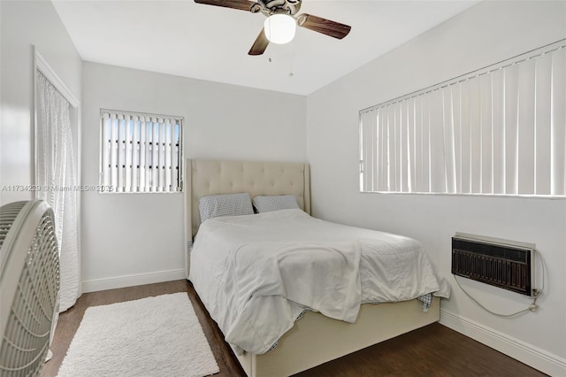 bedroom with dark hardwood / wood-style floors, a wall mounted AC, and ceiling fan