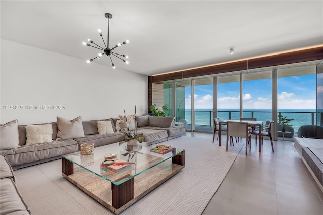 living room featuring floor to ceiling windows, a water view, and a notable chandelier