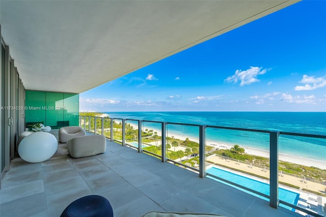 balcony featuring a water view and a beach view