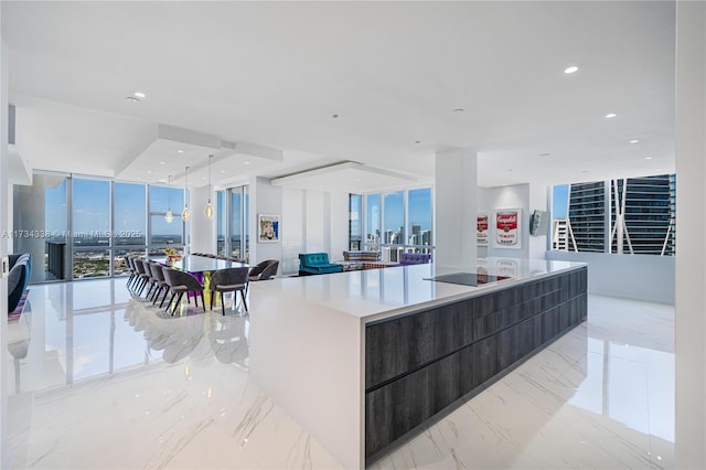 kitchen with black electric cooktop, a wall of windows, and a large island