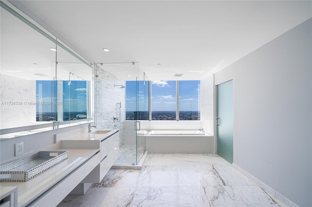 bathroom with vanity, a wealth of natural light, and separate shower and tub