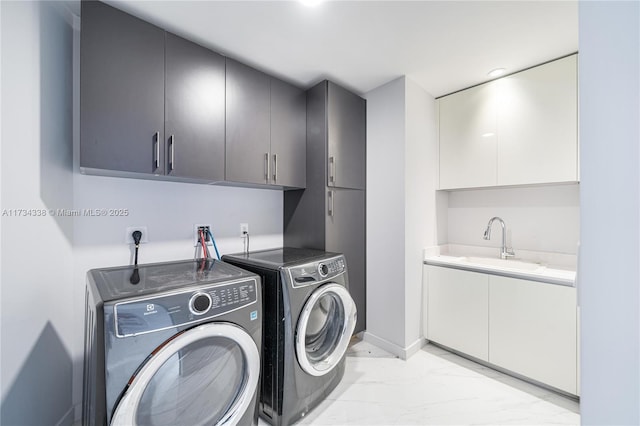 clothes washing area with cabinets, sink, and independent washer and dryer