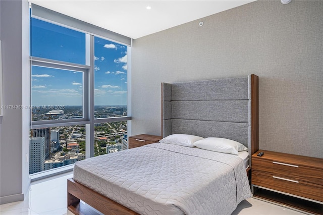 bedroom featuring multiple windows and a wall of windows