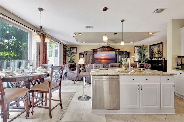 kitchen featuring sink, light stone countertops, light tile patterned floors, and white cabinets