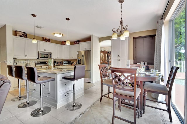 kitchen featuring hanging light fixtures, white cabinetry, appliances with stainless steel finishes, and light tile patterned floors