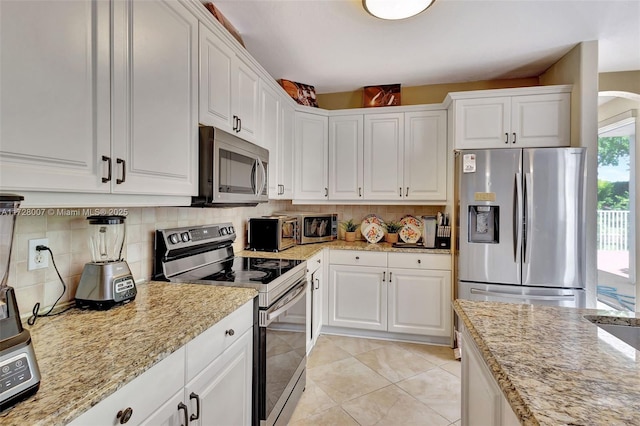 kitchen featuring tasteful backsplash, appliances with stainless steel finishes, and white cabinets