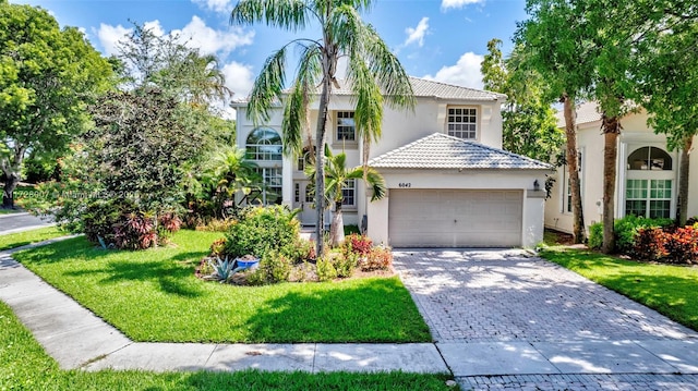 mediterranean / spanish-style home featuring a garage and a front lawn