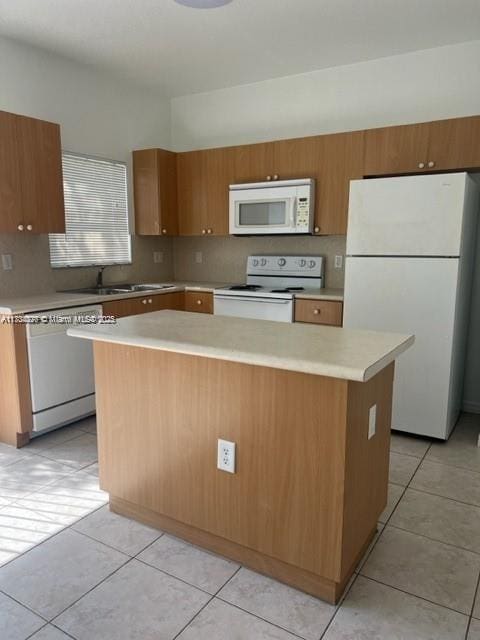 kitchen featuring a center island, sink, white appliances, and light tile patterned floors