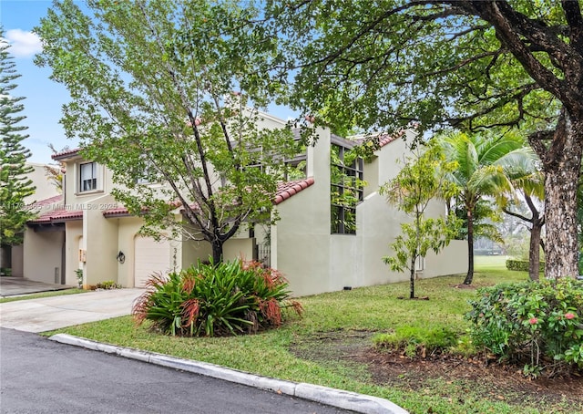 mediterranean / spanish-style home with a garage and a front lawn