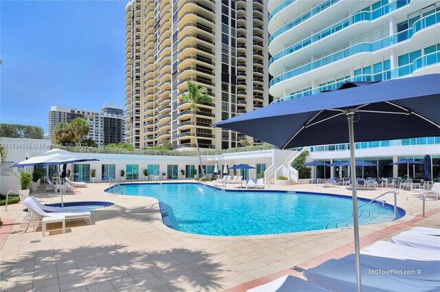 view of pool with a patio and a community hot tub