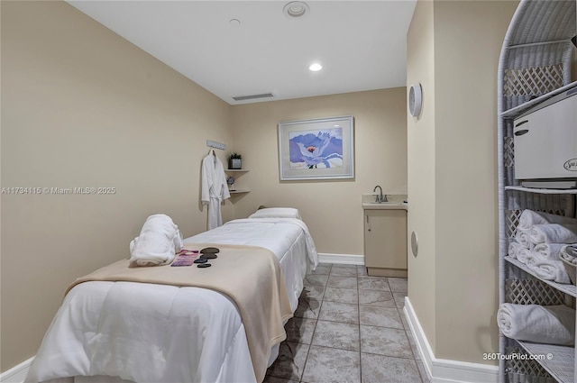 bedroom with sink and light tile patterned floors