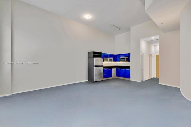 unfurnished living room featuring rail lighting