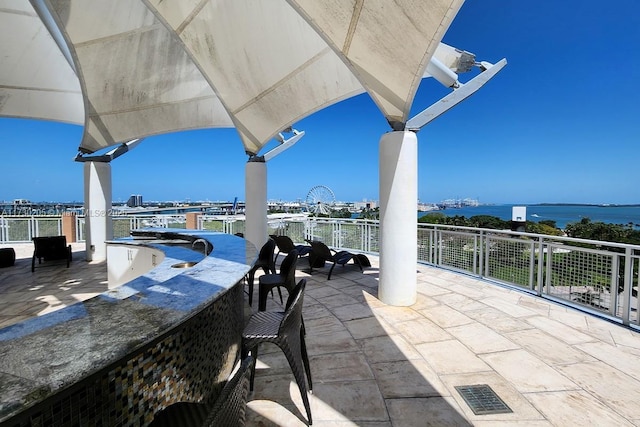 view of patio featuring a water view and exterior bar