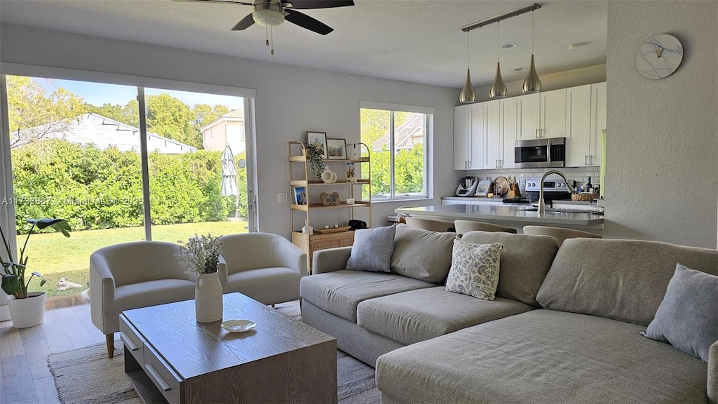 living room featuring hardwood / wood-style floors and ceiling fan